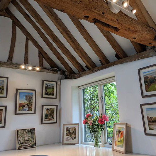 Multiple frames of made from various materials hanging in a white room